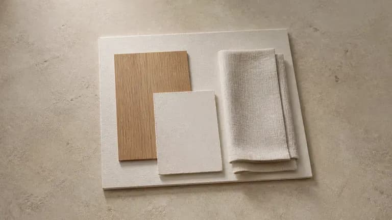An interior material board with wood veneer, plaster chips and linen curtain fabric on a coffee table